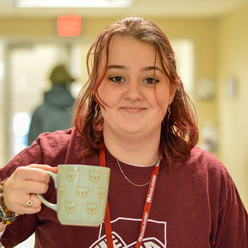 Angie holding decorative coffee mug