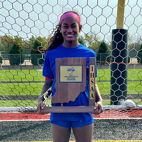 Kymaia holding IHSAA soccer trophy